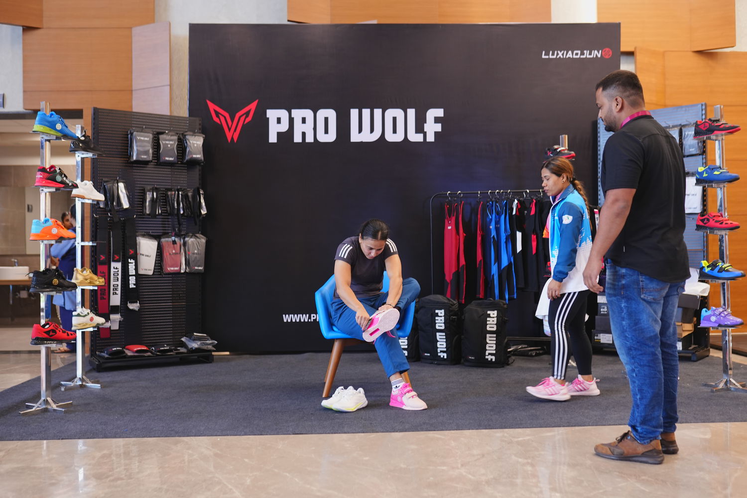 Two people trying on shoes in a store with 'Pro Wolf' branding.